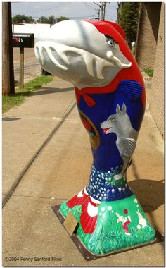 a colorful vase sitting on top of a sidewalk