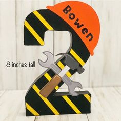 a wooden sign with a wrench and hammer on it that says rowan 2nd birthday