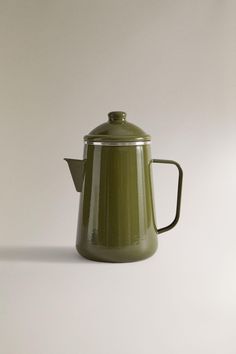 a green coffee pot sitting on top of a white table