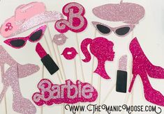 pink and black photo booth props with the word barbie on them