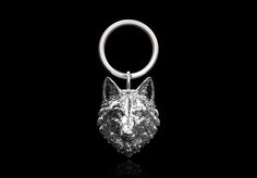 a metal keychain with a wolf head on it