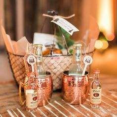 copper mugs and bottles are sitting on a table