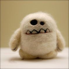 a white stuffed animal with black eyes and teeth