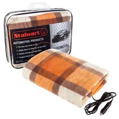 an orange and white plaid blanket sitting on top of a metal box next to a charger