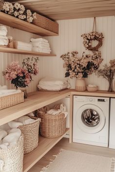 a washer and dryer in a small room with baskets on the shelves next to it