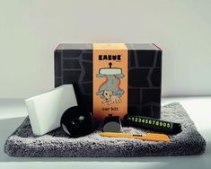 an assortment of items are displayed on a towel in front of a box that says tarte