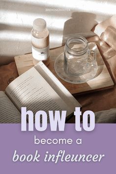 an open book sitting on top of a wooden table next to a jar of liquid