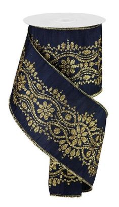 a roll of blue and gold ribbon on a white tablecloth with an intricate design