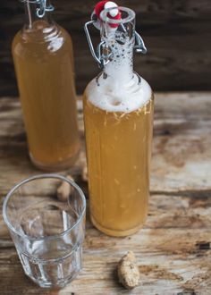 two bottles filled with liquid sitting on top of a wooden table