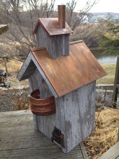 a wooden birdhouse with a copper roof