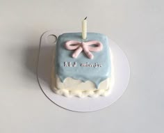 a blue and white cake with a candle on it