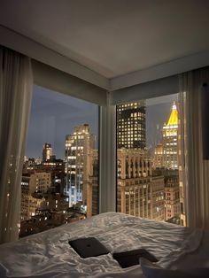 a bedroom with a view of the city at night