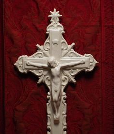 a white crucifix on a red wall