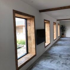 an empty room with three windows and a television on the wall in front of it