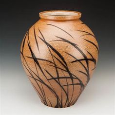 a brown and black vase sitting on top of a table