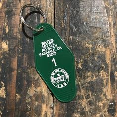 a green keychain sitting on top of a wooden table