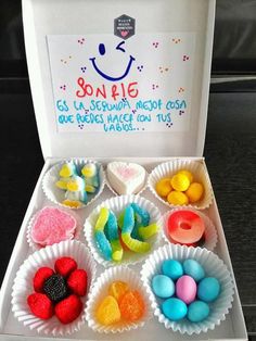 an open box filled with lots of different colored candies on top of a table