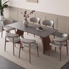 a dining room table with chairs around it and a vase filled with flowers on top