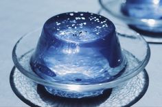 a glass plate with a blue hat on top of it next to another bowl filled with water