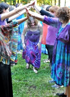 a group of women standing around each other holding hands