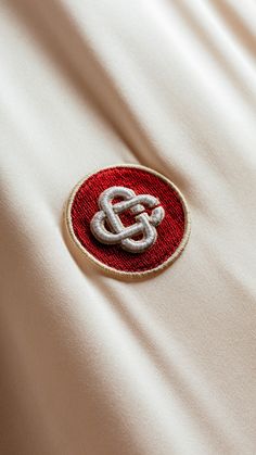 a red and white cloth with a small emblem on it's back side,