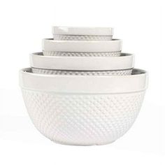 four white bowls stacked on top of each other