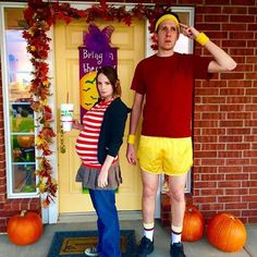 a man and woman dressed up in halloween costumes standing next to each other on the front porch