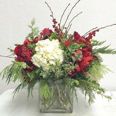 a glass vase filled with red and white flowers