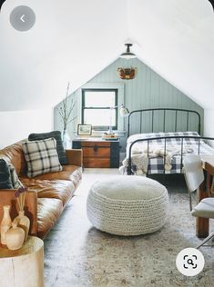 an attic bedroom with leather couches and rugs