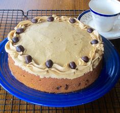 a cake sitting on top of a blue plate next to a cup and saucer