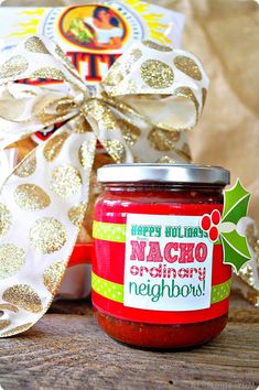 a jar of homemade christmas jam next to a gift box with a ribbon on it