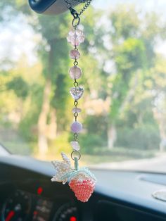 a car dashboard hanging from the dash board with beads and charms attached to it's side