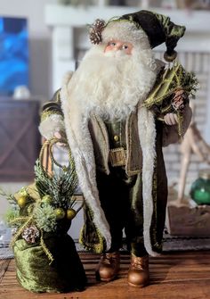 a santa clause doll standing next to a christmas tree ornament and ornaments on a wooden table