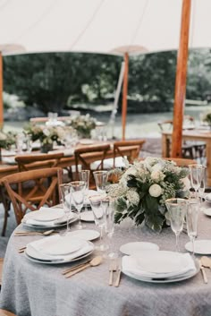 the table is set with plates, silverware and napkins for an elegant wedding reception