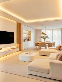 a living room filled with white furniture and a flat screen tv mounted on the wall