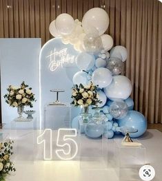 balloons and flowers are on display in front of a birthday sign with the number fifteen