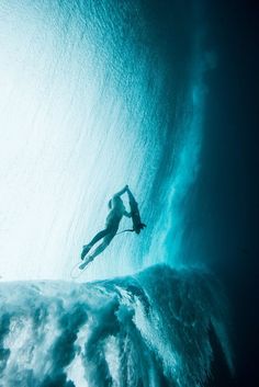 a man riding a wave on top of a surfboard in the middle of the ocean