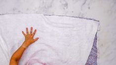 a child's hand on a white towel