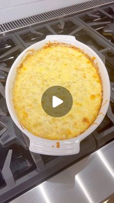 a casserole sitting on top of a stove in a white dish with a video play button