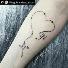 a heart shaped tattoo on the arm with an arrow and stars drawn in black ink