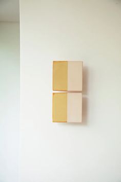 two square tiles mounted to the side of a wall