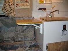 a small kitchenette with a sink and cupboards in an rv's living room