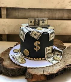 a cake decorated with money on top of a tree stump