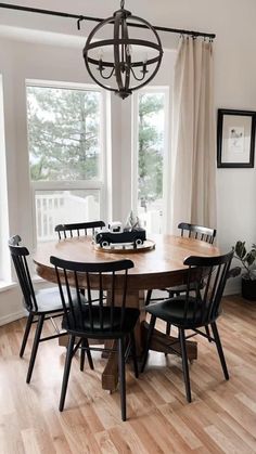 a dining room table with six chairs and a chandelier hanging from the ceiling