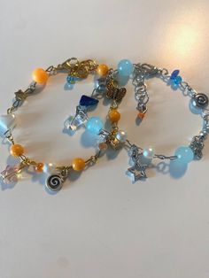 There are 2 bracelets! Theyre matching with eachother so you could give them to someone or keep both yourself. One is blue,silver and has a star charm, and the other is orange, gold and has a sun charm. Enjoy! Sun Charm, Sun And Stars, Silver Charm Bracelet, Matching Bracelets, Orange Gold, Star Charms, Jewelry Ideas, Silver Charms, Blue And Silver