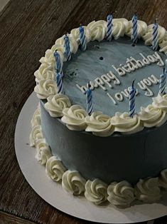 a birthday cake with white frosting and blue candles