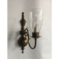 an old fashioned wall light with a glass shade