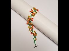 a beaded bracelet is laying on top of a roll of white paper and it's contents are sitting on the table