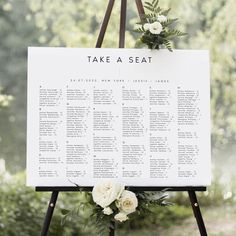 a wedding seating sign with flowers on it