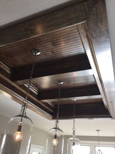 three lights hanging from the ceiling in a kitchen